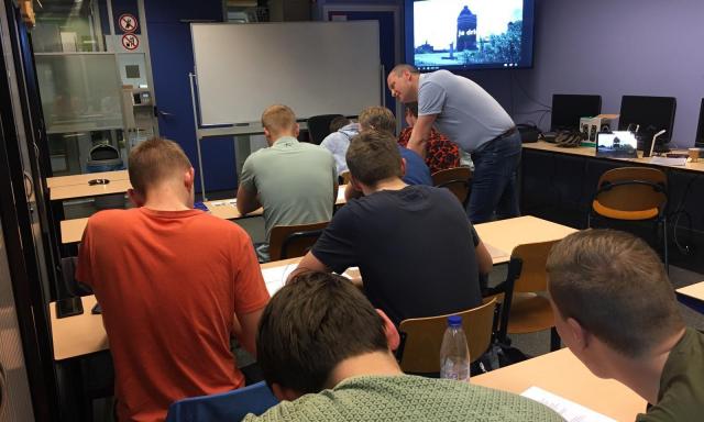 Tom geeft les aan studenten van het ROC.